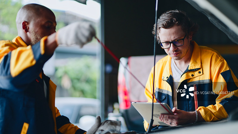 汽车修理工在修理厂使用汽车诊断工具图片素材