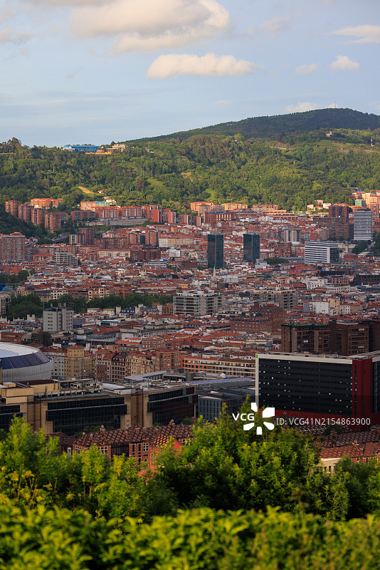 带有翠绿前景和山丘的现代毕尔巴鄂城市景观图片素材