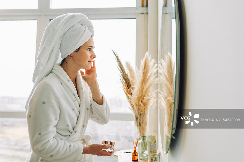 在浴室使用爽肤水的素颜女性图片素材