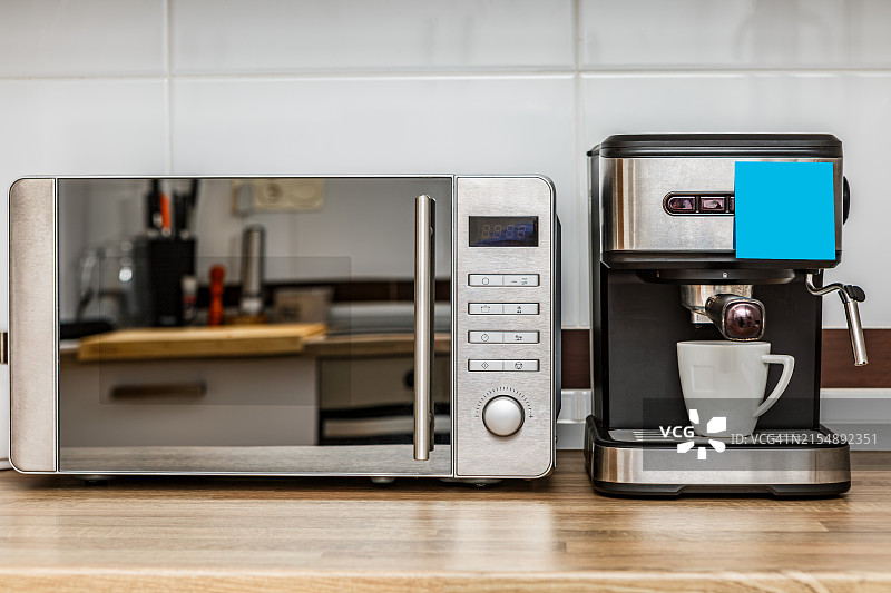 早晨的现代厨房台面，配有不锈钢微波炉和意式咖啡机图片素材