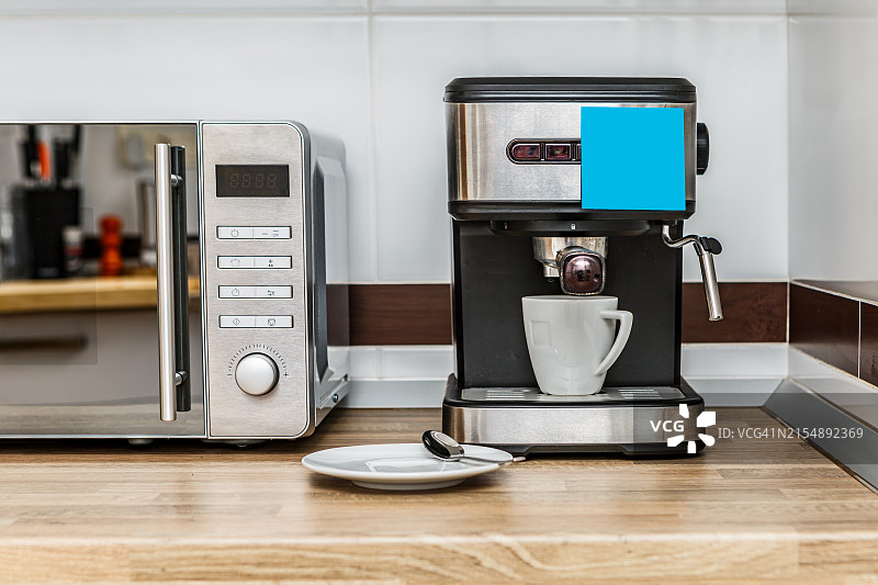 明亮日光下的现代厨房台面、意式咖啡机和微波炉图片素材