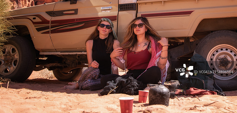 两个女孩坐在沙漠中图片素材