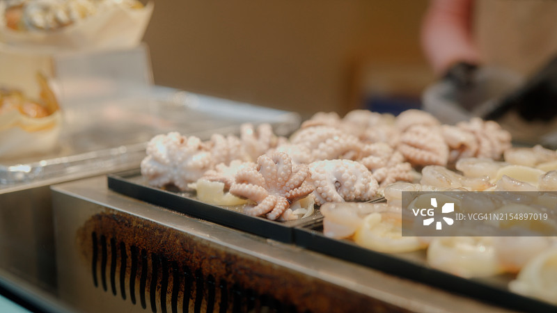 厨师在日本街头市场烹饪章鱼烧图片素材