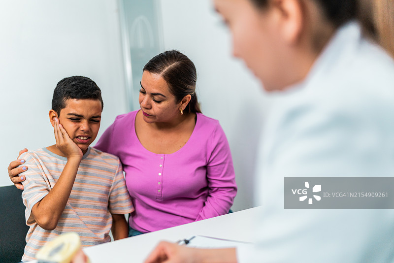 孩子和母亲在牙医诊所与牙医交谈图片素材