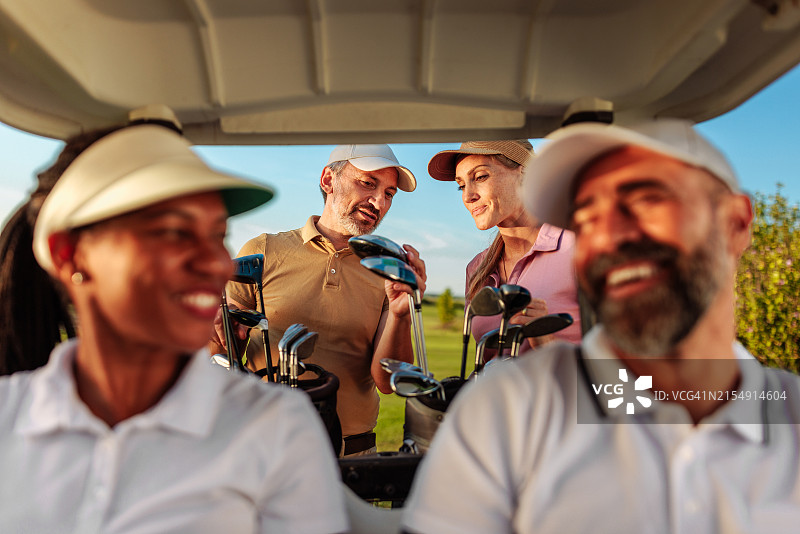 两对情侣乘坐高尔夫球车打高尔夫图片素材