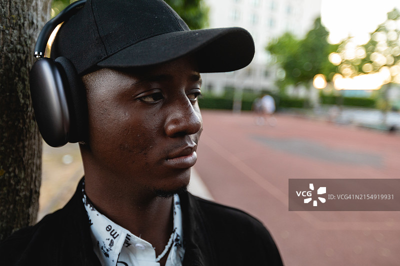 街头时尚黑人男子佩戴无线耳机听音乐图片素材