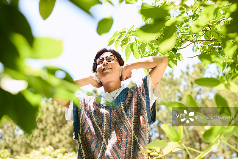 阳光明媚的日子里在树荫下荡秋千的Z世代图片素材