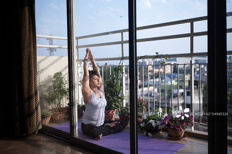 阳光阳台上俯瞰城市景观的宁静冥想图片素材