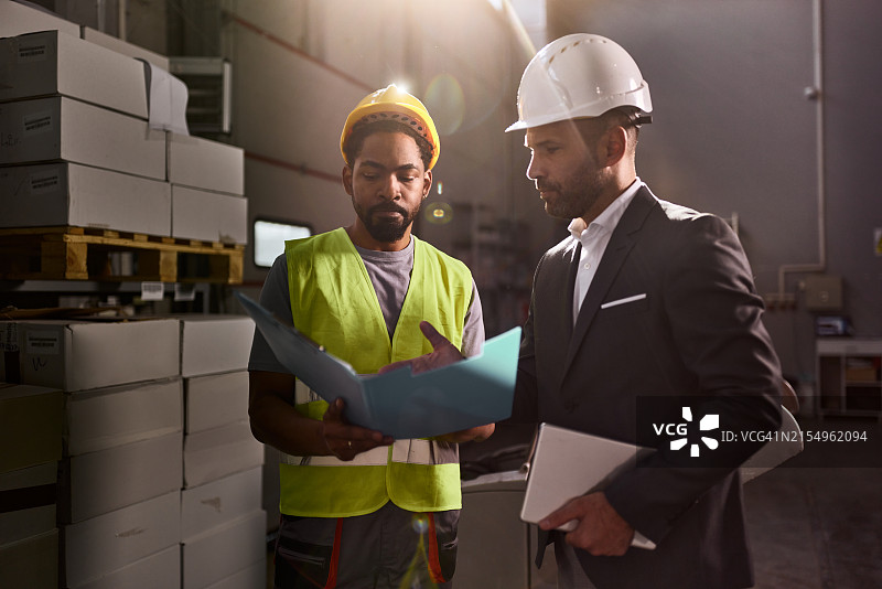 黑色男人和他的经理在储藏室里阅读文件图片素材