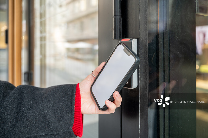 手持智能手机通过智能数字锁开门图片素材