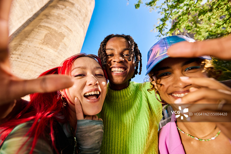 三位Z世代年轻人在户外自拍，城市环境，低角度拍摄图片素材