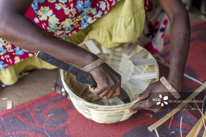 印度古吉拉特邦纳尔默达地区的少数民族妇女在村庄里编织篮子图片素材