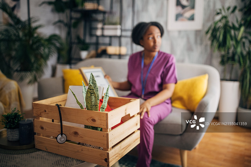 沉思的护士在舒适的家庭环境中休息图片素材