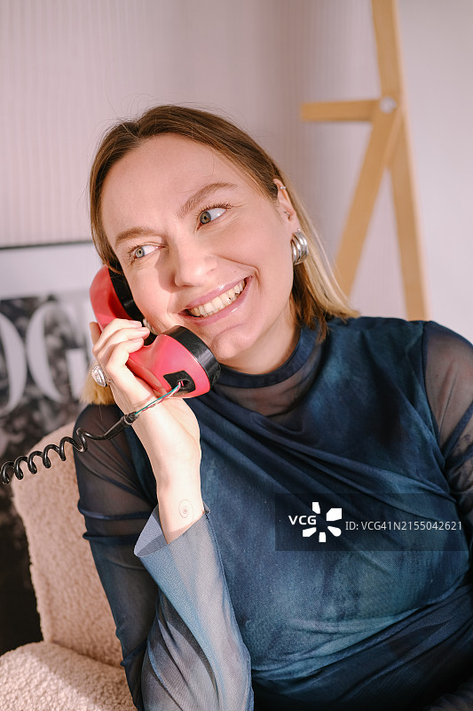 年轻女子手持复古电话听筒微笑交谈图片素材