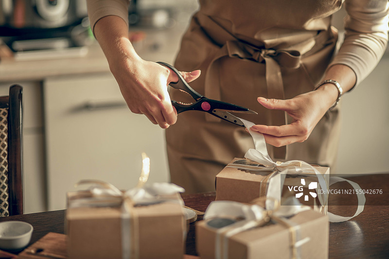 女店主为顾客订单剪彩图片素材