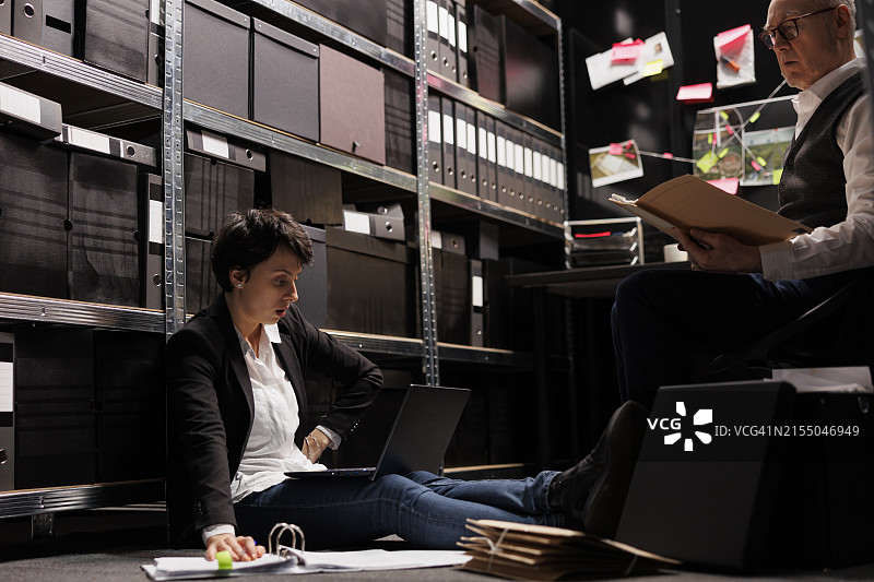 坐在档案室地板上的女私人侦探图片素材