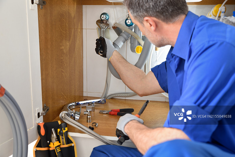 水管工在房屋厨房进行维修图片素材