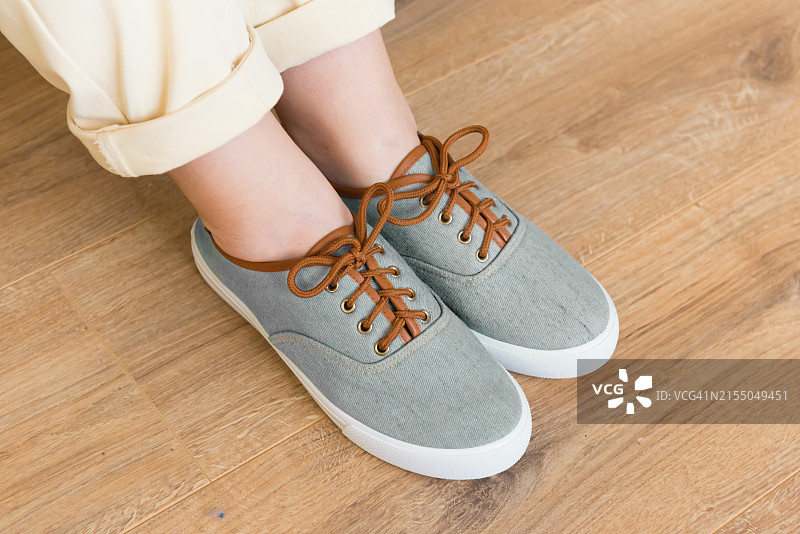 孩子穿着鞋站在硬木地板上的下半身视角图片素材
