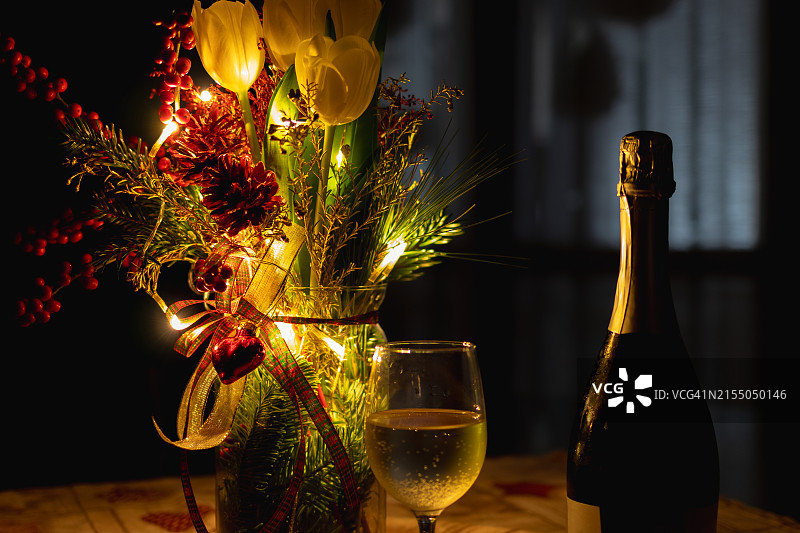 烛光下桌子上葡萄酒瓶和鲜花的特写图片素材
