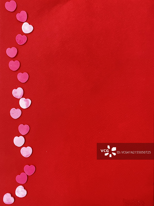红色背景上用五彩纸屑制成的心形高角度视图图片素材
