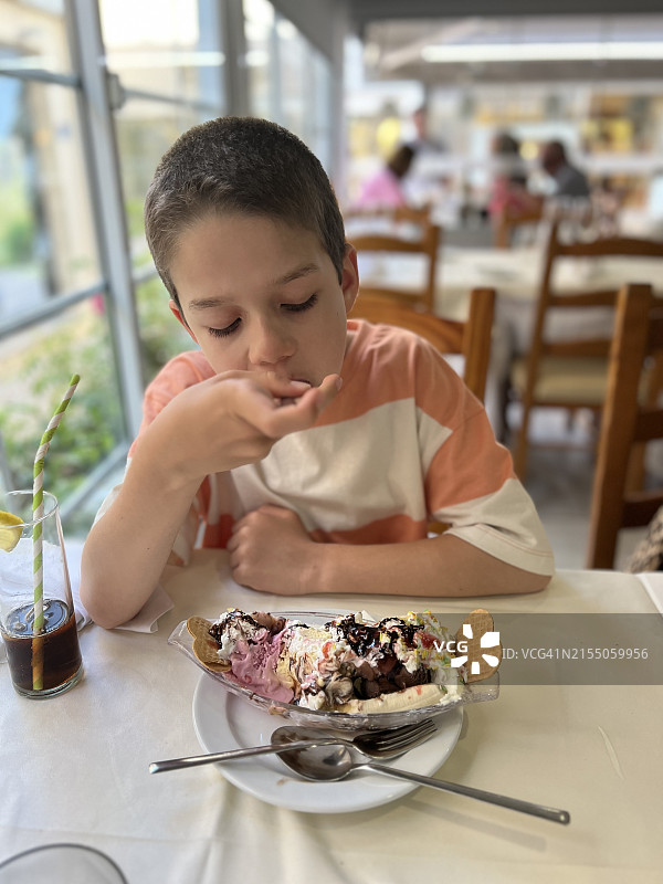 特写镜头下吃香蕉船冰淇淋的男孩图片素材