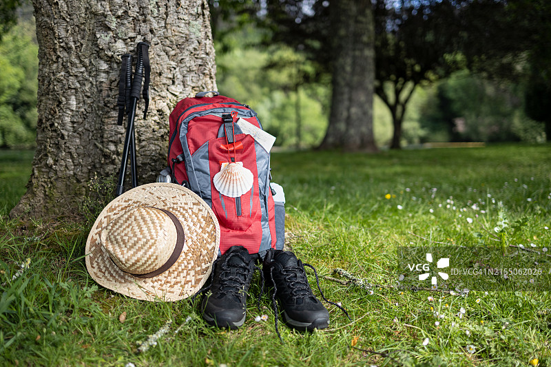 背着背包坐在田野上的女人的下半身图片素材