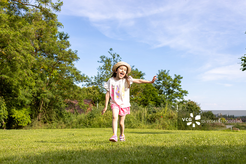 快乐小女孩在草地上奔跑图片素材