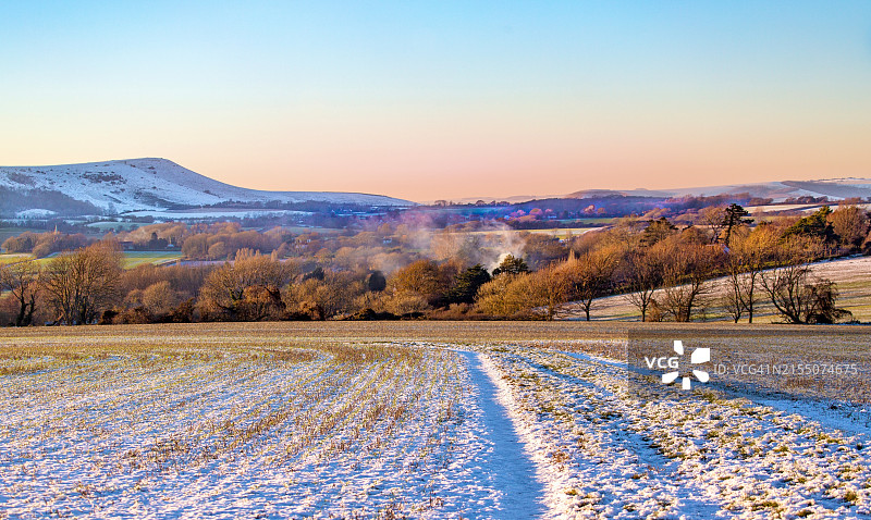 从英国东萨塞克斯郡威明顿看到的白雪皑皑的冬日下午的南丘图片素材