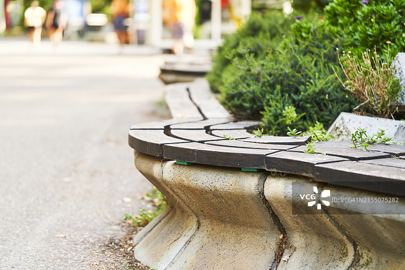 游乐园里带长凳的石墙侧视图，白天有草地图片素材