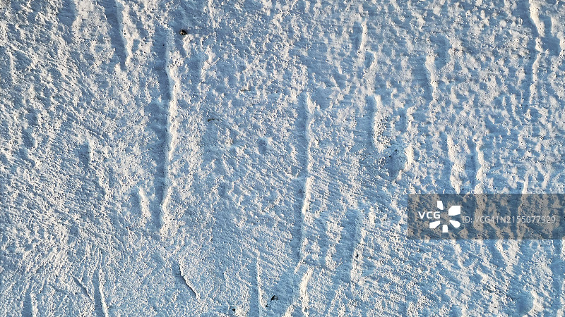 粗糙纹理白色墙壁的特写。表面凹槽和压痕的详细视图图片素材