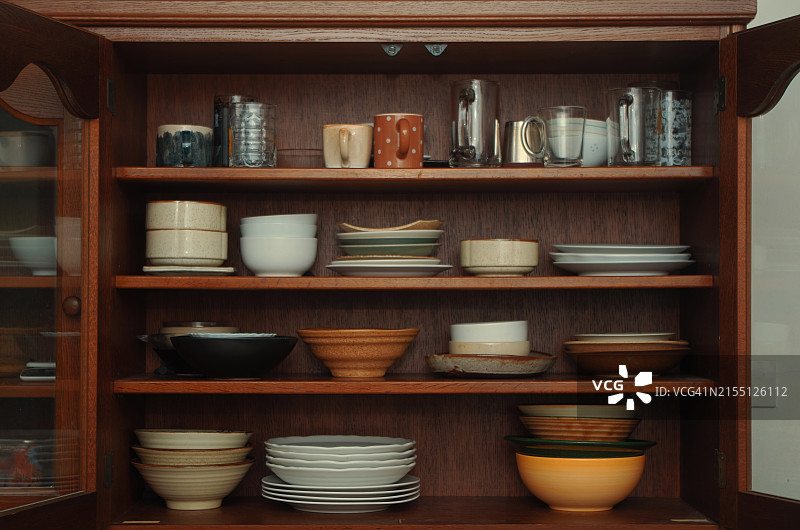 储物柜中摆放着陶器，乡村风格的架子上摆放着有组织的陶器和饮用玻璃杯图片素材