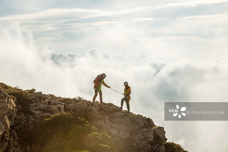 两人在山上，其中一人拿着绳子图片素材