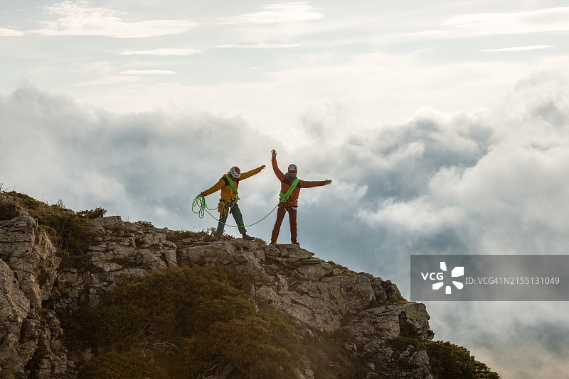 两个人站在山顶拿着绿色绳索图片素材