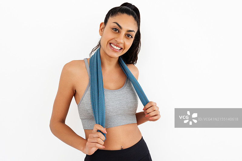 穿运动服的快乐运动女人站在白墙前图片素材