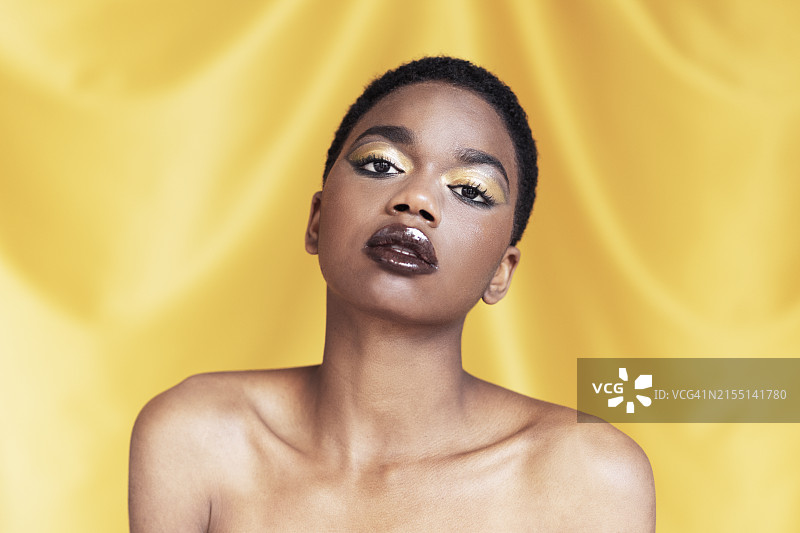 在黄色背景下化妆的美丽女人图片素材