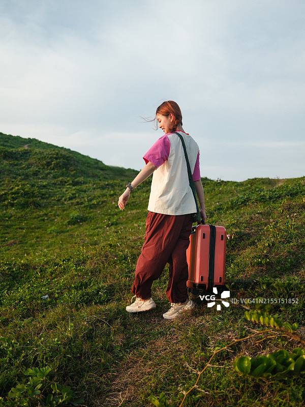 独自在草坪上手提箱的亚洲女人图片素材