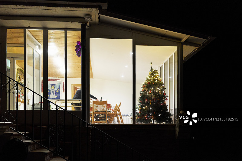 透过窗户看到的房子里的圣诞树（夜间，正面视角）图片素材