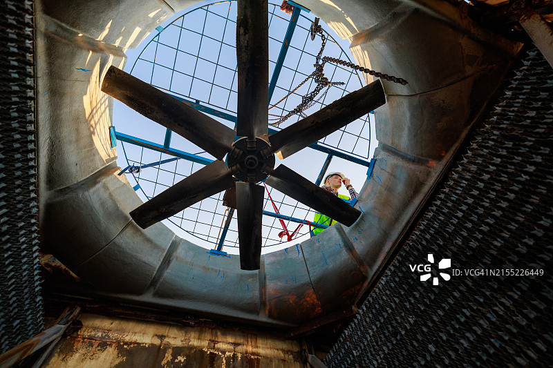 维护工程师在屋顶检查和维护空调系统的冷却塔图片素材