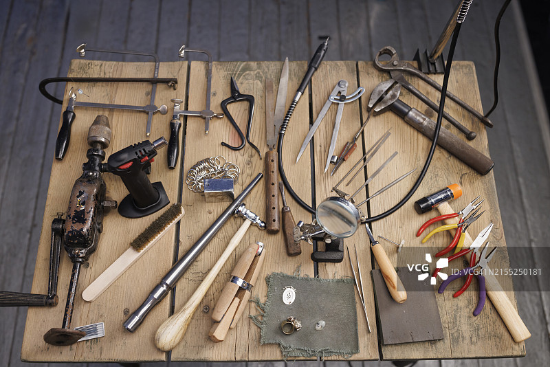 珠宝商工作室：乡村木桌上的复古和现代珠宝工具图片素材