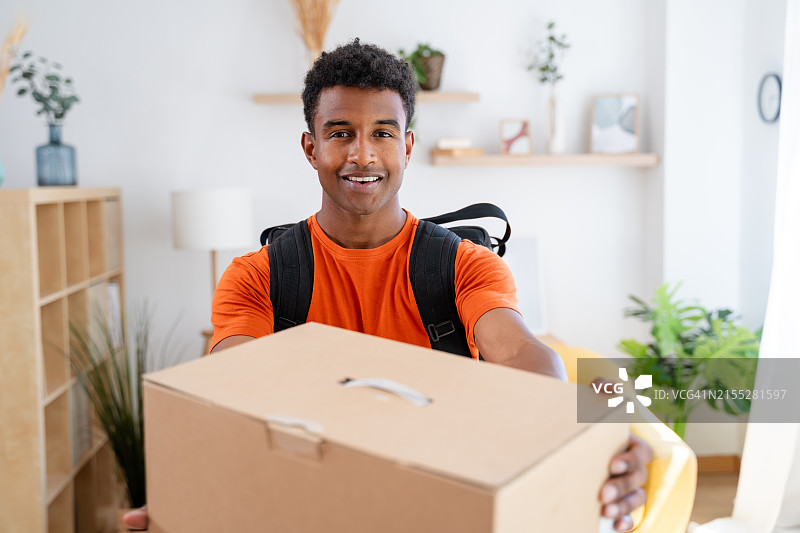 快递员微笑递送纸箱图片素材