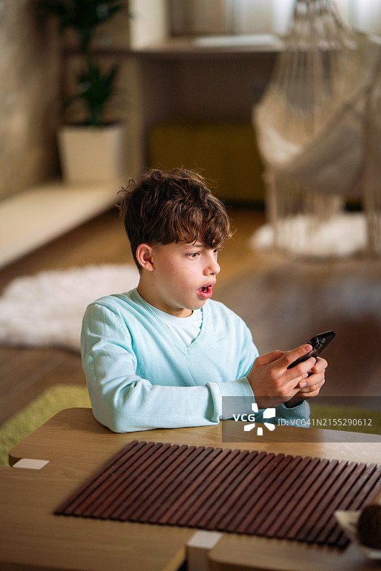 男孩难以置信地看着手机图片素材