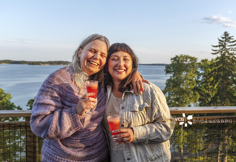 在海边享受鸡尾酒的快乐女性朋友图片素材
