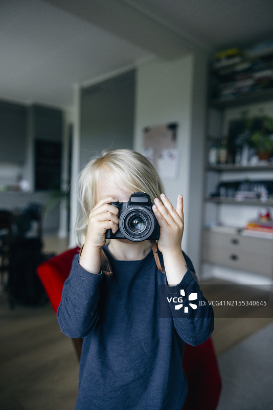 男孩在家通过相机拍照图片素材