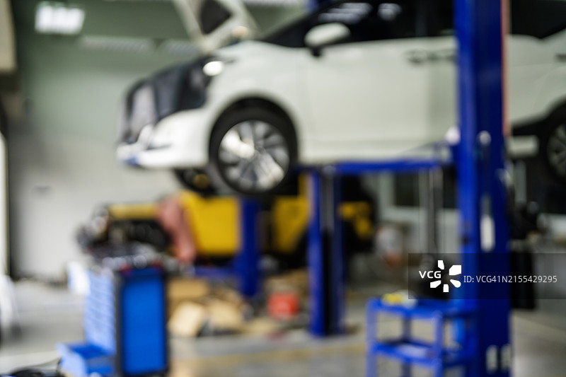 维修服务站，现代汽车正在维修，技术人员在二极管灯背景下工作图片素材