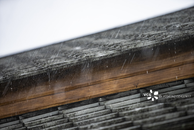 暴雨和大风吹袭屋顶，倾盆大雨的特写，极端气候概念图片素材