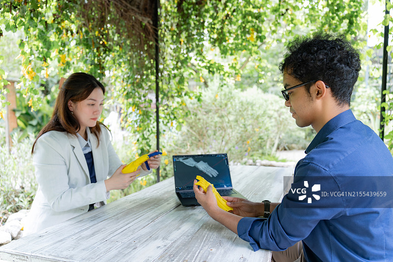 两位亚洲中年男女同事在宁静的自然环境中讨论工作图片素材