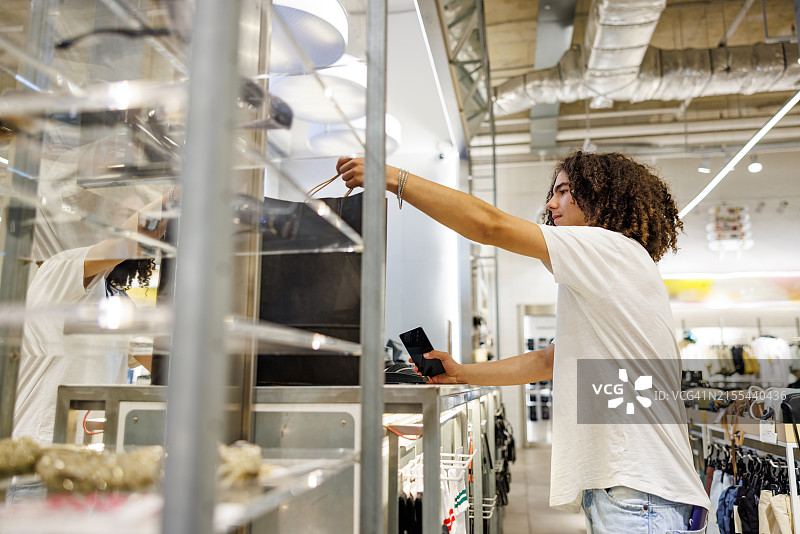 拿着购买的衣物的青少年男孩图片素材