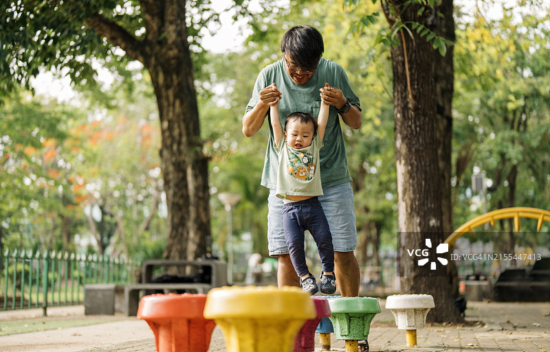 父亲在公园指导儿子玩耍图片素材
