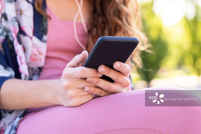 夏天，一位女士正在用手机打字图片素材