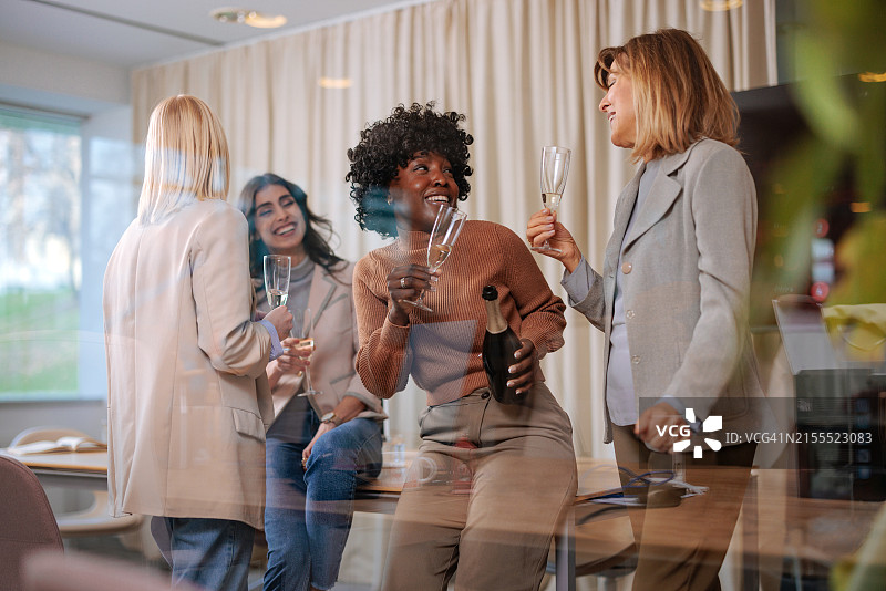 快乐的商业女性在办公室庆祝图片素材